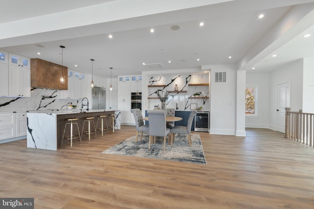 dining room with recessed lighting, visible vents, light wood finished floors, and baseboards