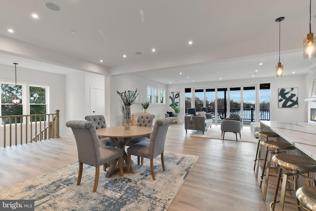 dining space featuring recessed lighting, light wood-type flooring, and an inviting chandelier