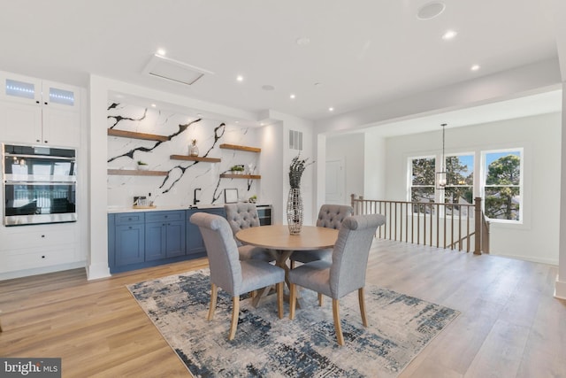 dining space featuring light wood finished floors, visible vents, and recessed lighting