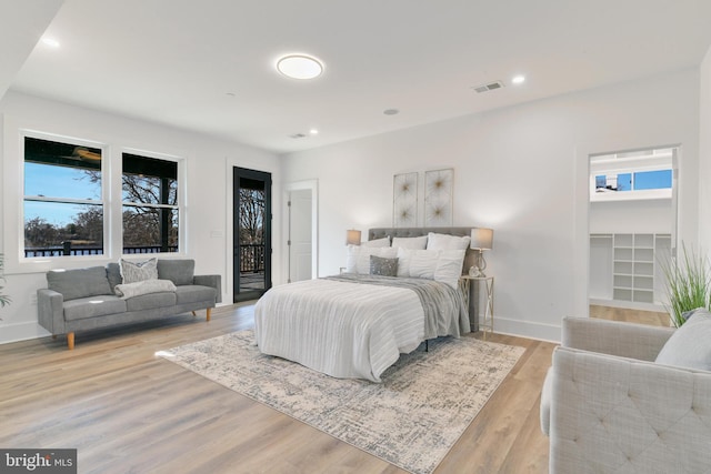 bedroom featuring recessed lighting, light wood-style flooring, baseboards, and access to outside