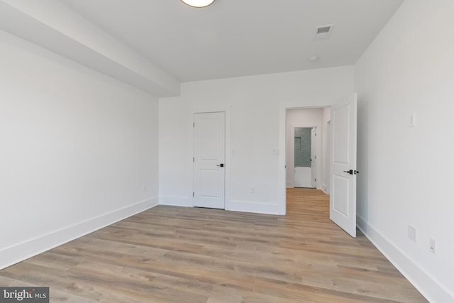 unfurnished bedroom with visible vents, baseboards, and light wood-style floors