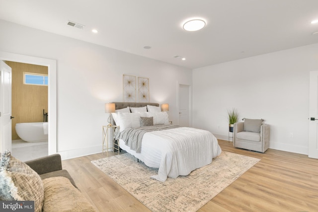 bedroom with visible vents, baseboards, light wood-type flooring, recessed lighting, and ensuite bath