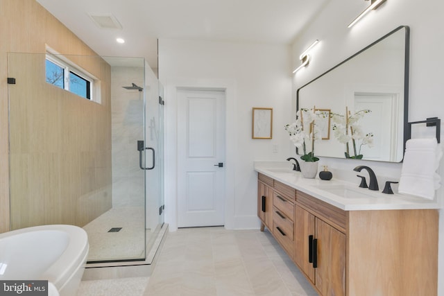 bathroom with a freestanding bath, a shower stall, double vanity, and a sink