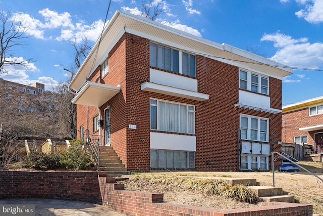 view of front of house with brick siding and fence