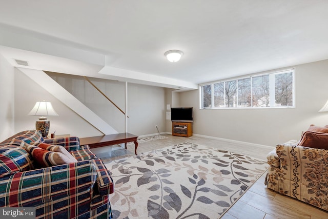 living room with visible vents, baseboards, and stairway