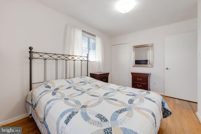 bedroom featuring a closet, baseboards, and light wood-style flooring