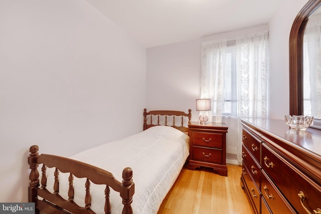 bedroom with multiple windows and light wood-style flooring