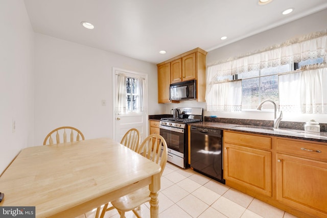 kitchen with light tile patterned floors, recessed lighting, dark stone countertops, black appliances, and a sink