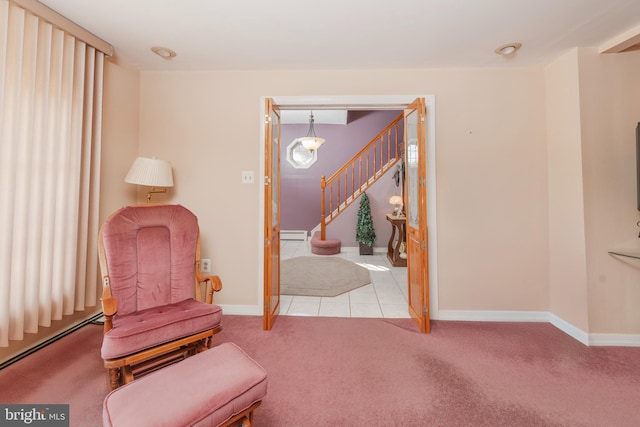 sitting room with a baseboard heating unit, baseboards, stairs, and carpet