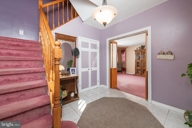 entryway featuring tile patterned flooring, stairs, and baseboards