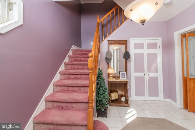 stairway with tile patterned floors and baseboards