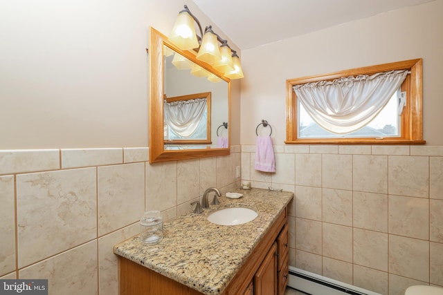 half bath featuring vanity, tile walls, a wainscoted wall, and a baseboard heating unit