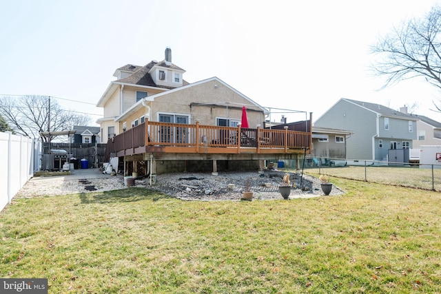 rear view of property with a wooden deck, a lawn, and a fenced backyard