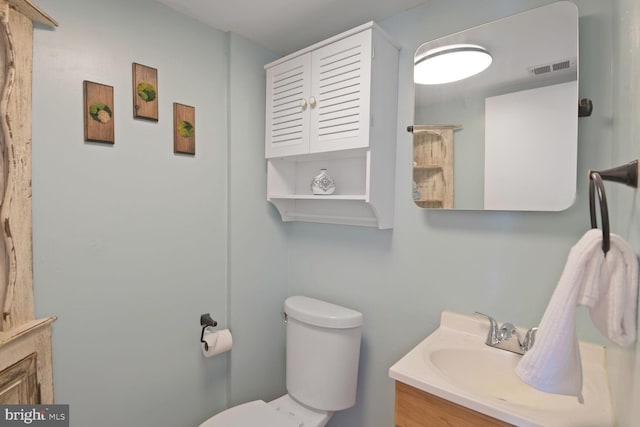 bathroom with visible vents, toilet, and vanity