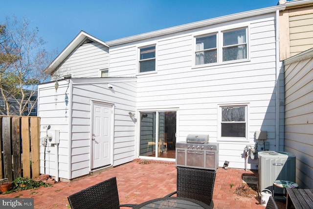 back of property with cooling unit, fence, and a patio area