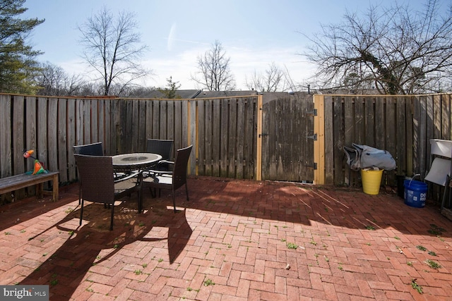 view of patio featuring outdoor dining space, a gate, and fence private yard