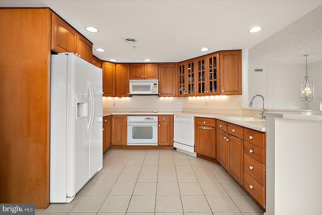 kitchen with white appliances, light tile patterned floors, a sink, glass insert cabinets, and brown cabinets