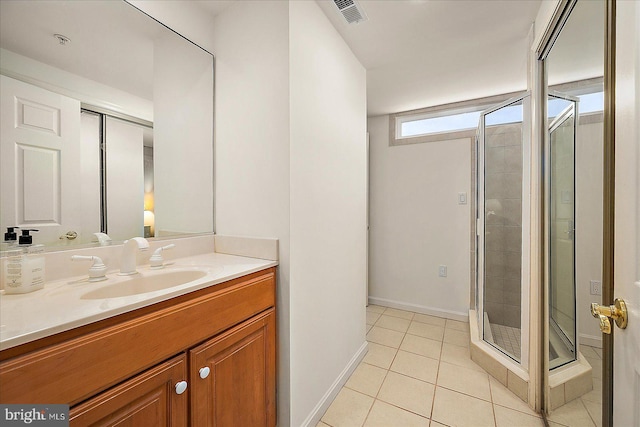 bathroom featuring visible vents, a stall shower, tile patterned flooring, baseboards, and vanity