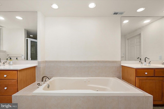 bathroom featuring vanity, visible vents, a whirlpool tub, and a stall shower