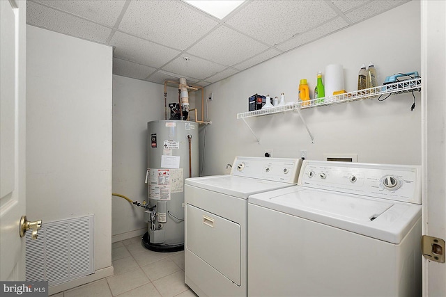 clothes washing area featuring gas water heater, washer and clothes dryer, light tile patterned floors, and laundry area