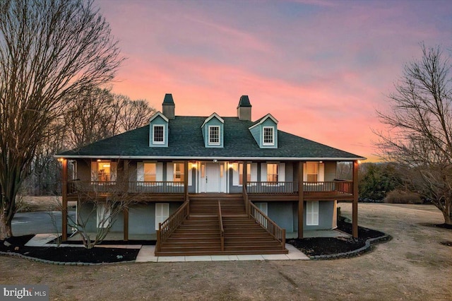 view of front facade featuring stairs, a porch, and a chimney