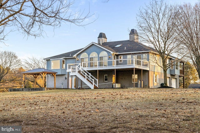 back of house with a chimney, stairs, a gazebo, a garage, and a deck