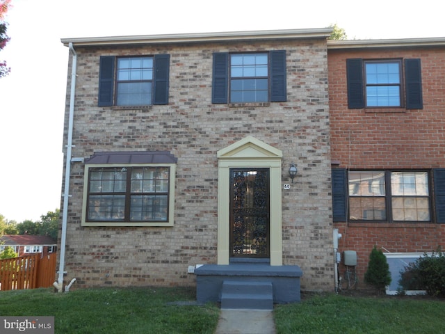 view of front of home featuring fence and brick siding