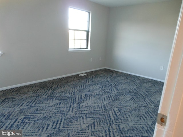 unfurnished room featuring carpet flooring, visible vents, and baseboards