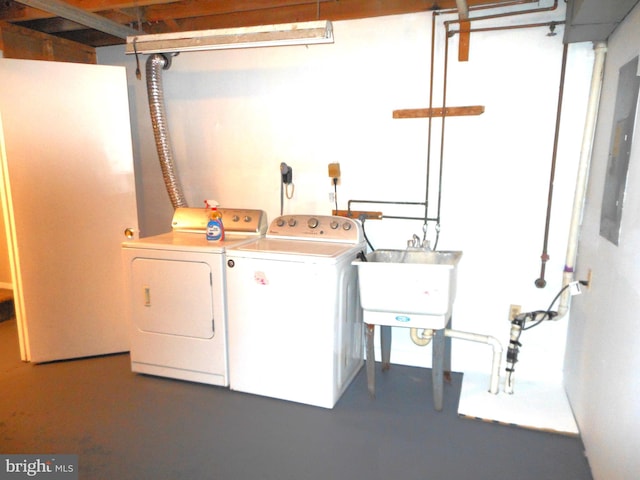 clothes washing area featuring a sink, laundry area, and washer and clothes dryer