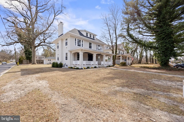 view of front of home with dirt driveway, a porch, and a chimney