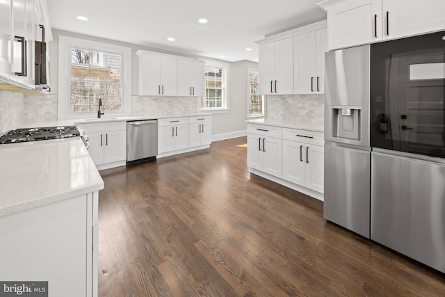 kitchen featuring dark wood-type flooring, a sink, recessed lighting, appliances with stainless steel finishes, and white cabinets