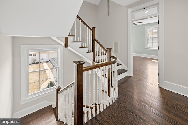 stairway featuring visible vents, a healthy amount of sunlight, and wood finished floors