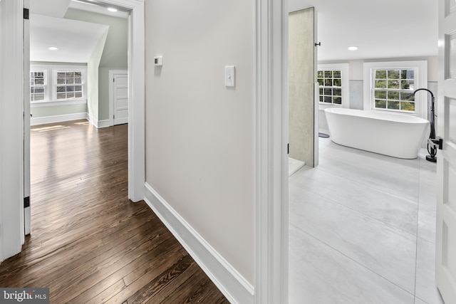 corridor with recessed lighting, baseboards, and hardwood / wood-style floors