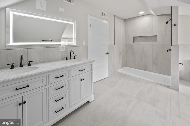 full bath featuring a sink, visible vents, tile walls, and a walk in shower