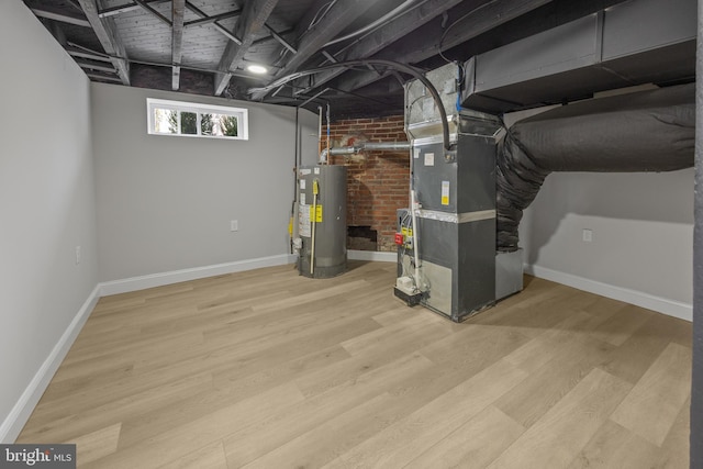 basement with heating unit, wood finished floors, water heater, and baseboards