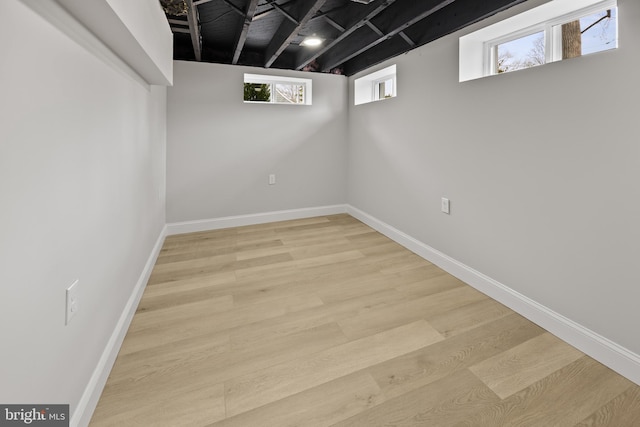 below grade area featuring baseboards and light wood finished floors