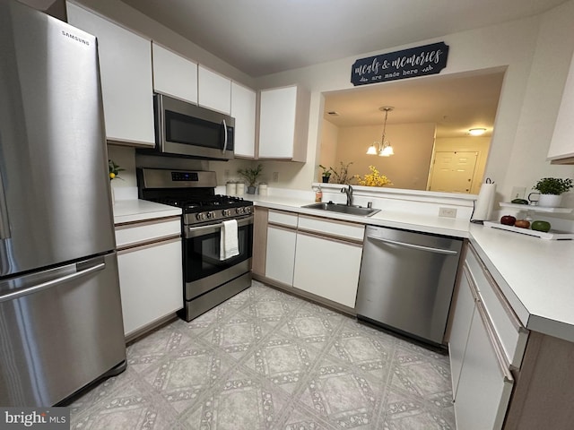 kitchen featuring a sink, stainless steel appliances, white cabinetry, and light countertops