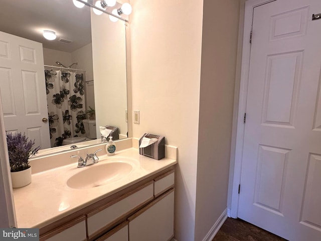 full bathroom with vanity, a shower with shower curtain, baseboards, visible vents, and toilet