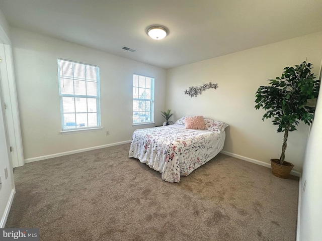 carpeted bedroom featuring baseboards and visible vents