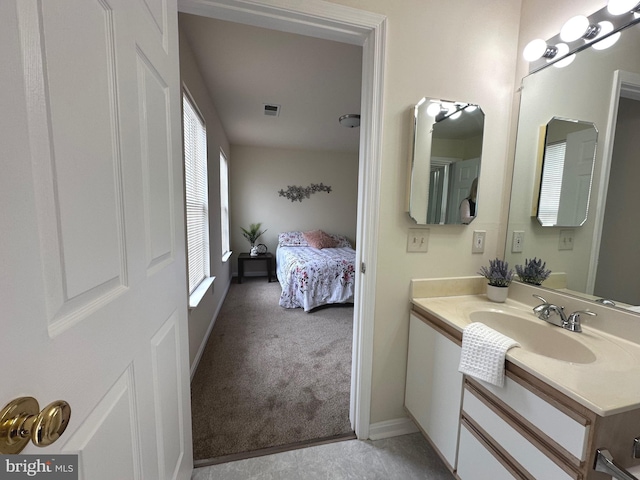 bathroom with visible vents, connected bathroom, vanity, and baseboards