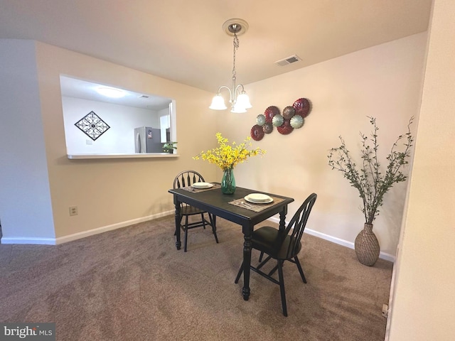 dining room featuring visible vents, dark carpet, an inviting chandelier, and baseboards