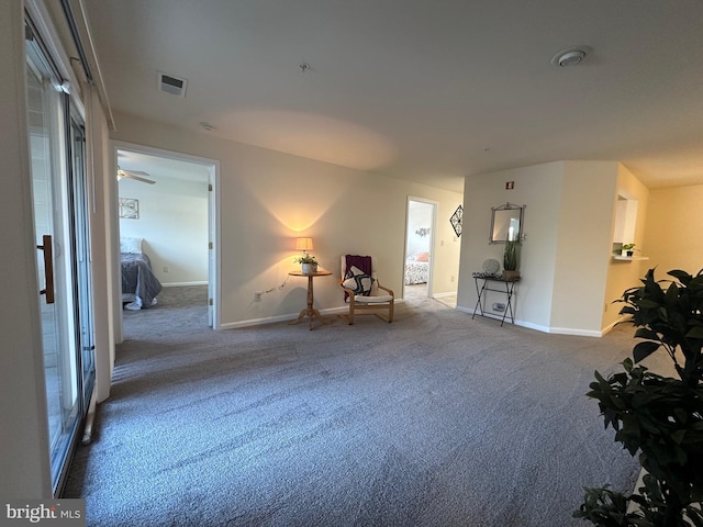 living area with visible vents, baseboards, and carpet