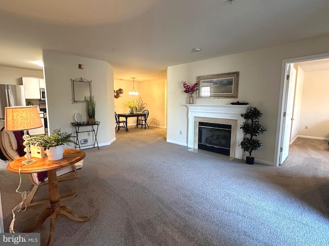 living area featuring a fireplace with flush hearth, baseboards, and carpet floors