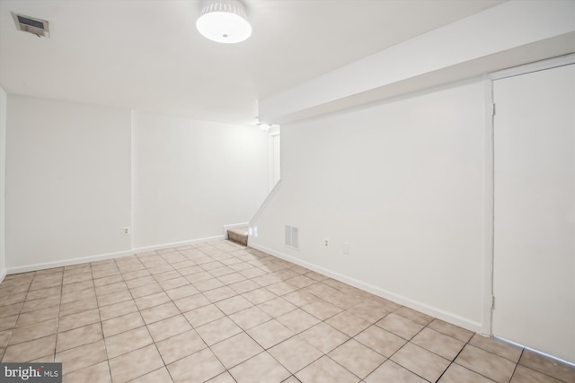 finished basement with visible vents, baseboards, and stairs