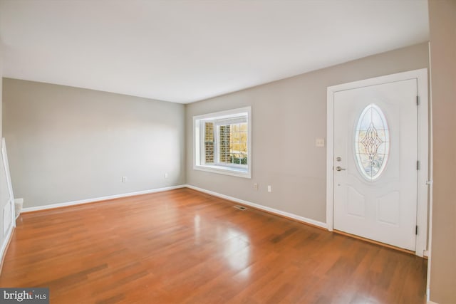 foyer entrance with baseboards and wood finished floors