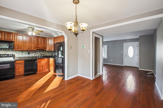 kitchen with black appliances, a sink, tasteful backsplash, dark countertops, and brown cabinetry