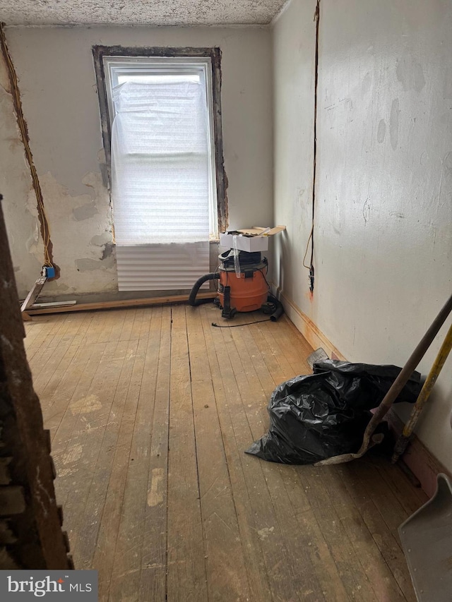 empty room featuring baseboards and wood-type flooring