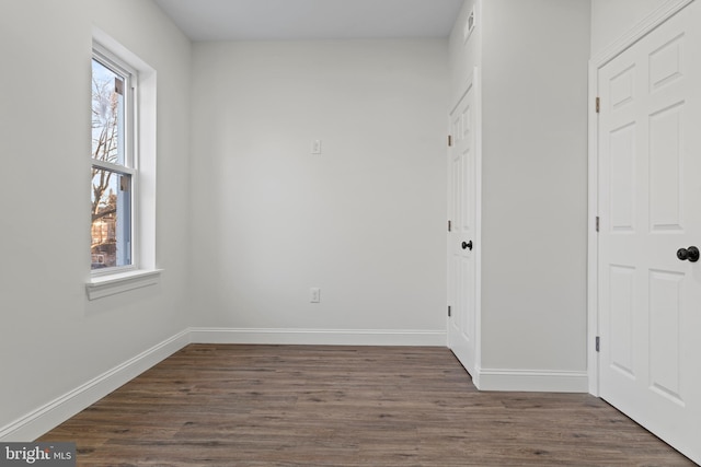 interior space featuring dark wood finished floors and baseboards