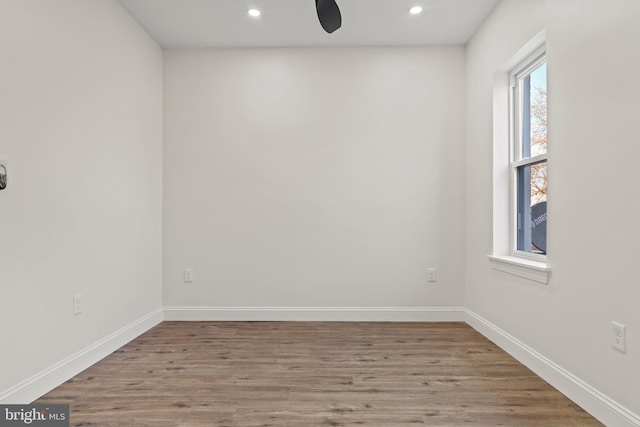 empty room featuring recessed lighting, baseboards, and wood finished floors