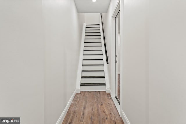 hall with recessed lighting, wood finished floors, and baseboards